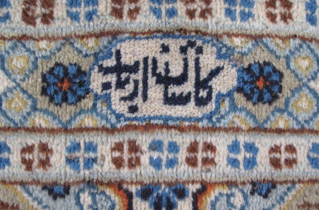 Signed Kashan-style ivory rug, curvilinear floral border detail