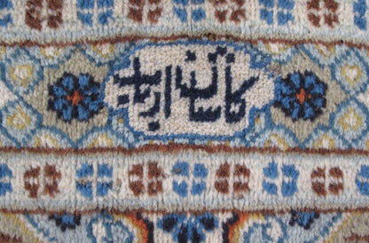 Signed Kashan-style ivory rug, curvilinear floral border detail