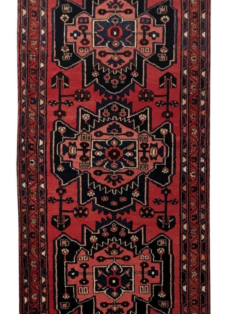 Rust red Hamadan-style runner, pile texture showing wool depth