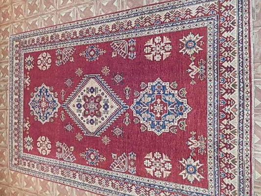 Afghan Kazak 6x8 rug, central medallion close-up in red and ivory