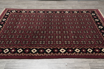 Turkman Bokhara burgundy rug, central gul medallion close-up on black field