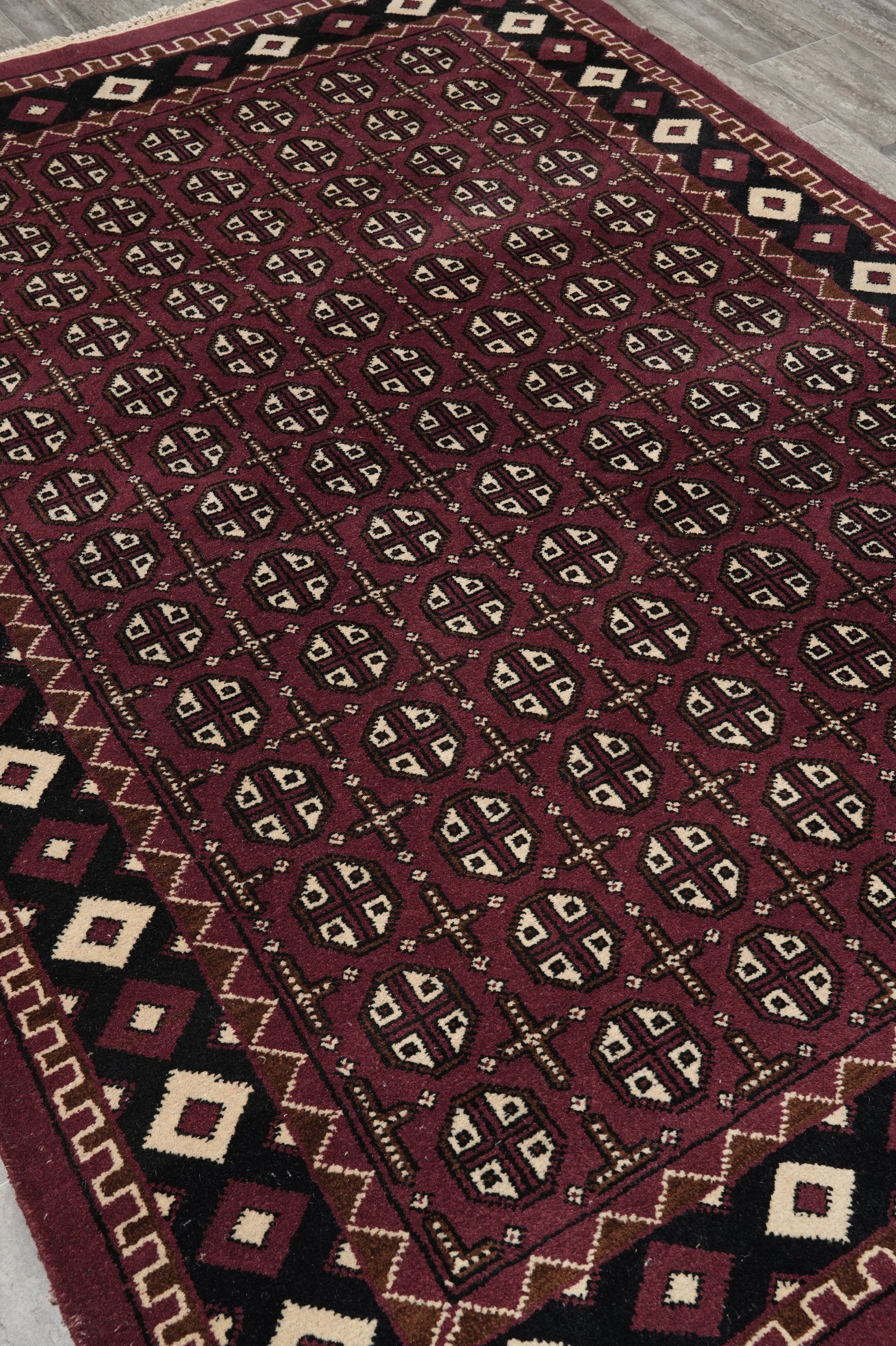 Turkman Bokhara burgundy rug, corner motif close-up