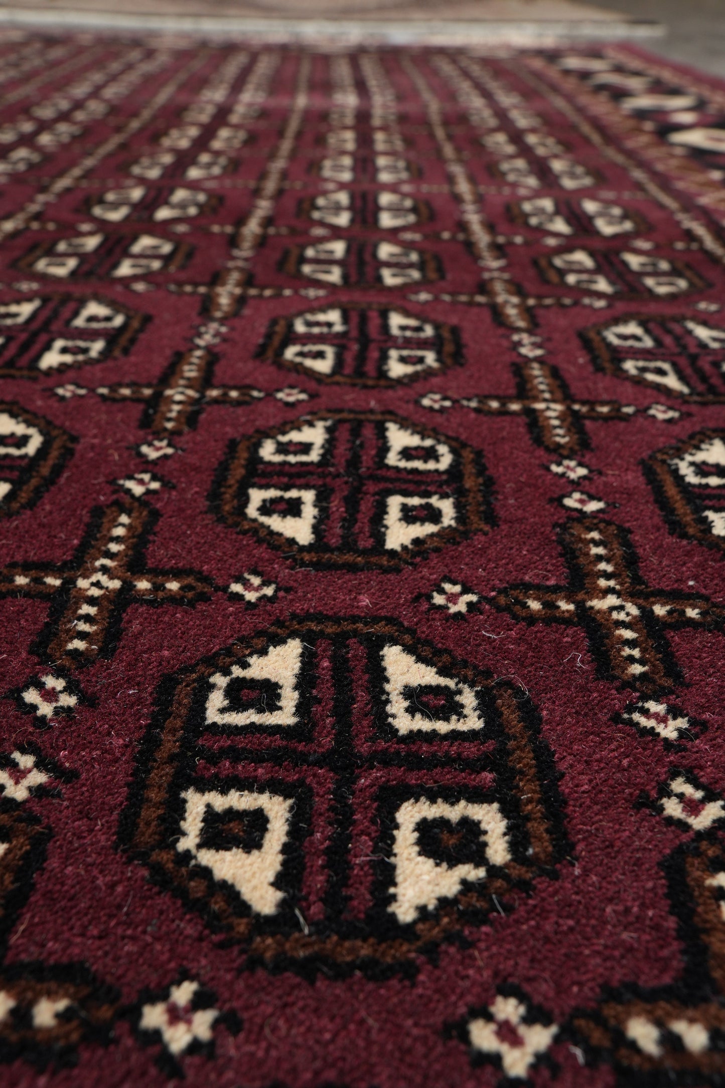Turkman Bokhara burgundy rug, color balance between burgundy and black field