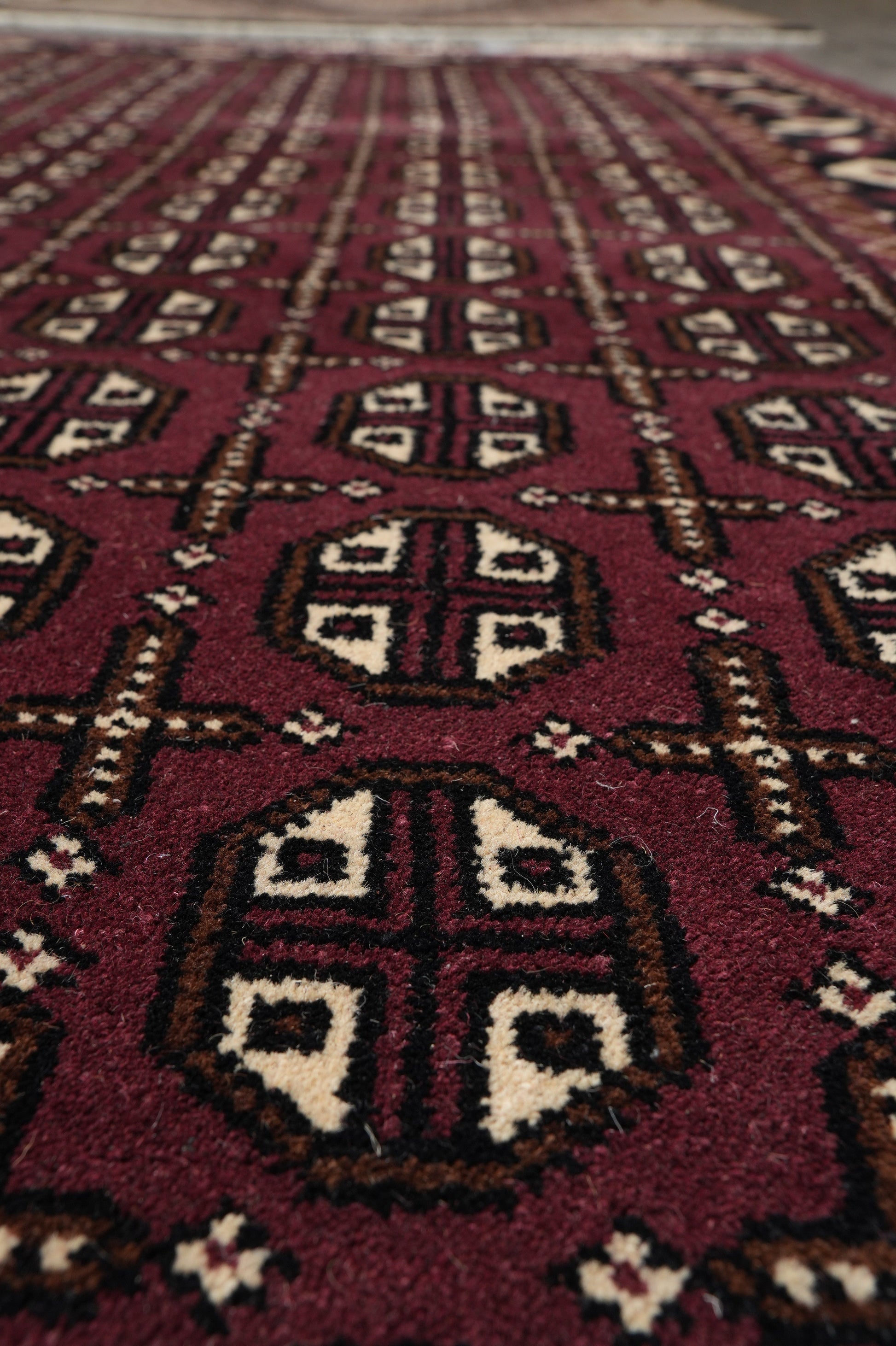 Turkman Bokhara burgundy rug, color balance between burgundy and black field