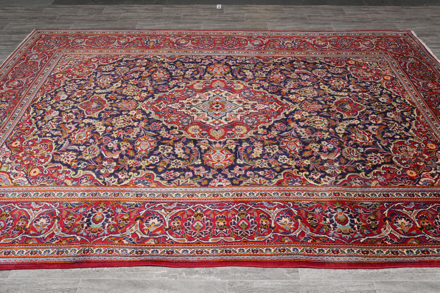 Kashan-style navy rug, curvilinear floral detail in red and ivory