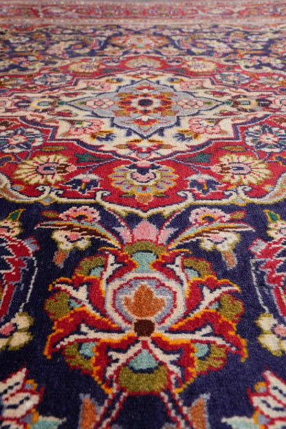 Kashan-style navy rug, mid-field floral vine detail