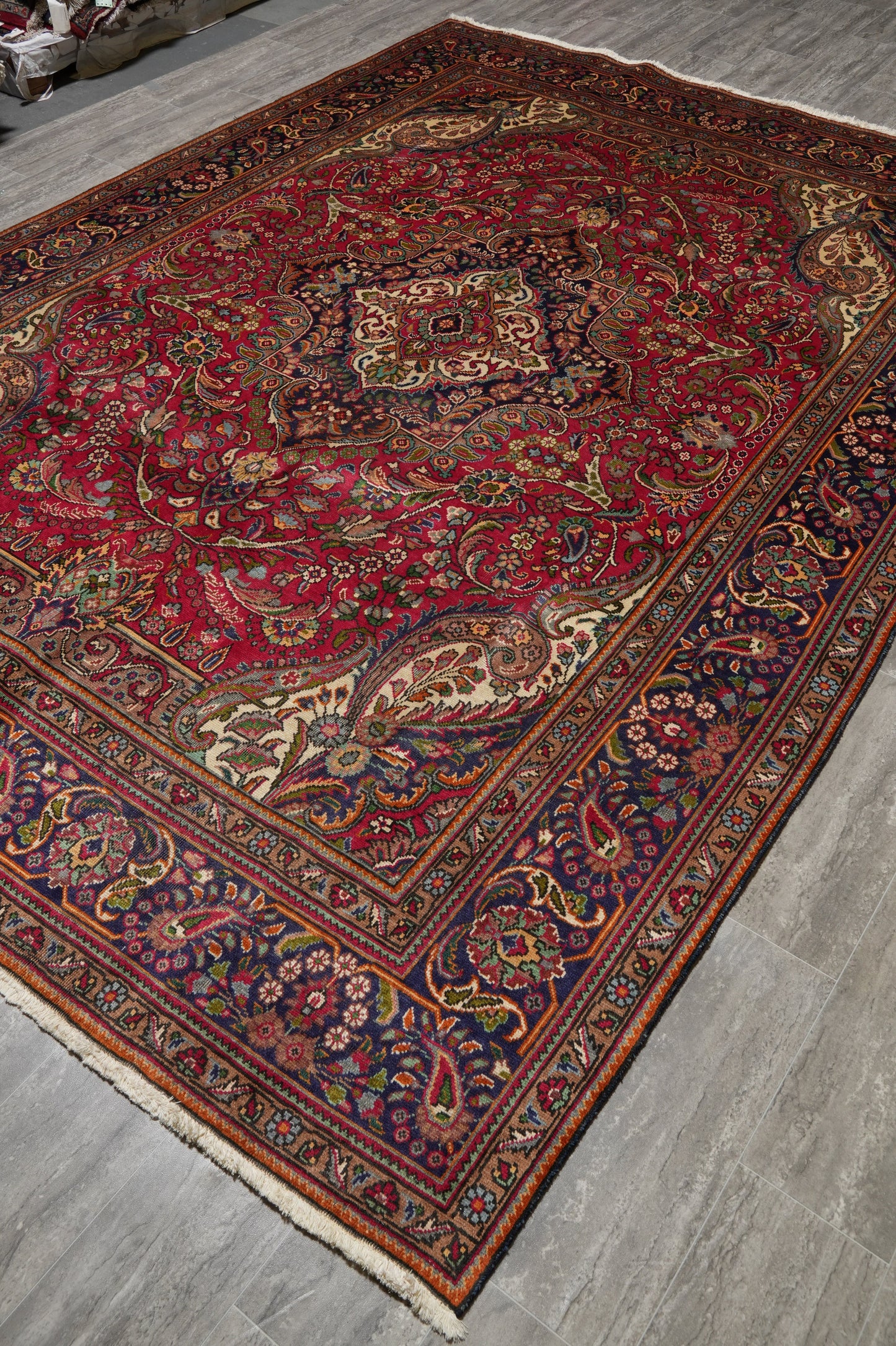 Pre-owned Tabriz-style blue rug, partial overhead view