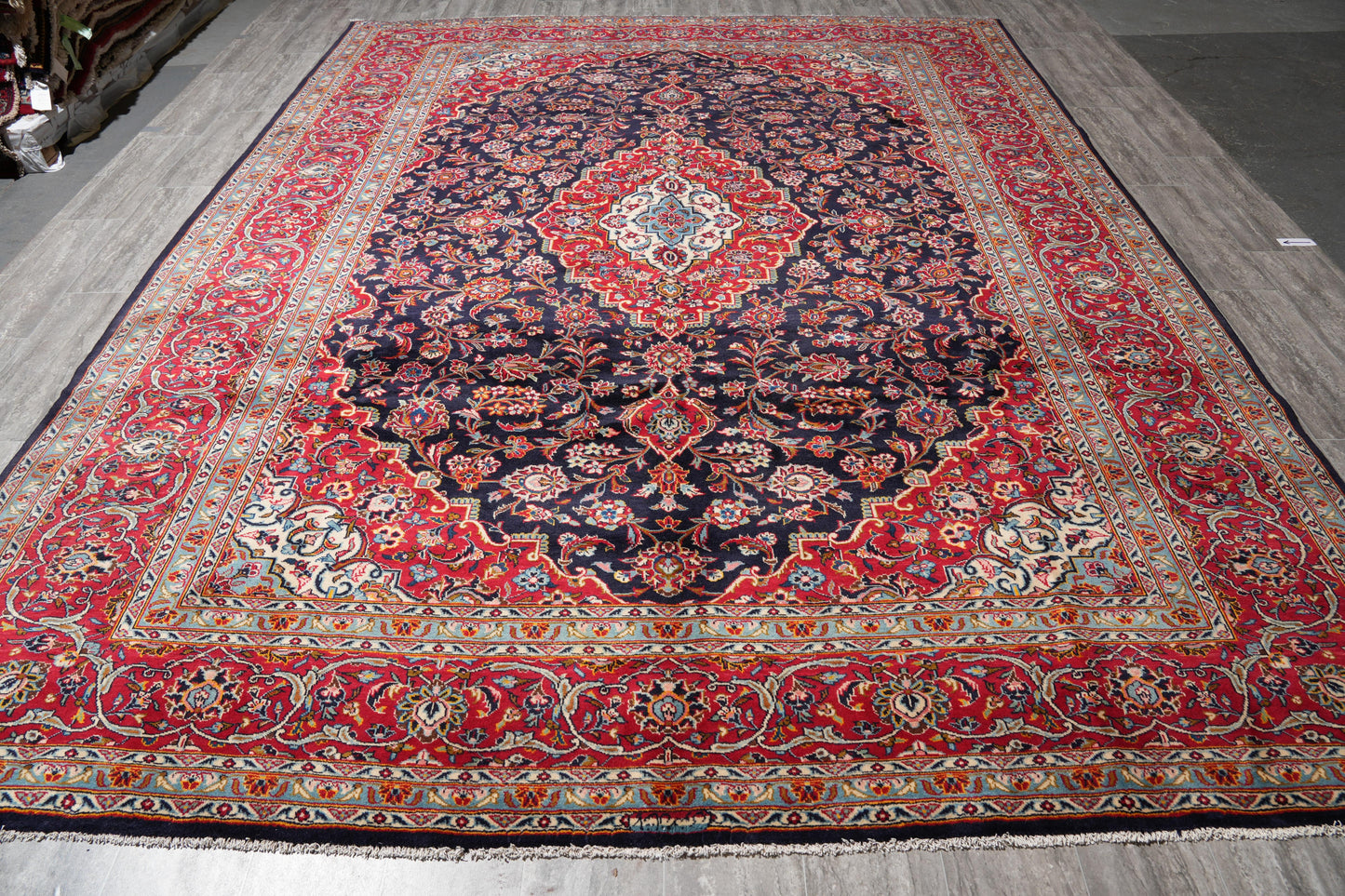 Signed Kashan-style navy rug, central ivory medallion close-up