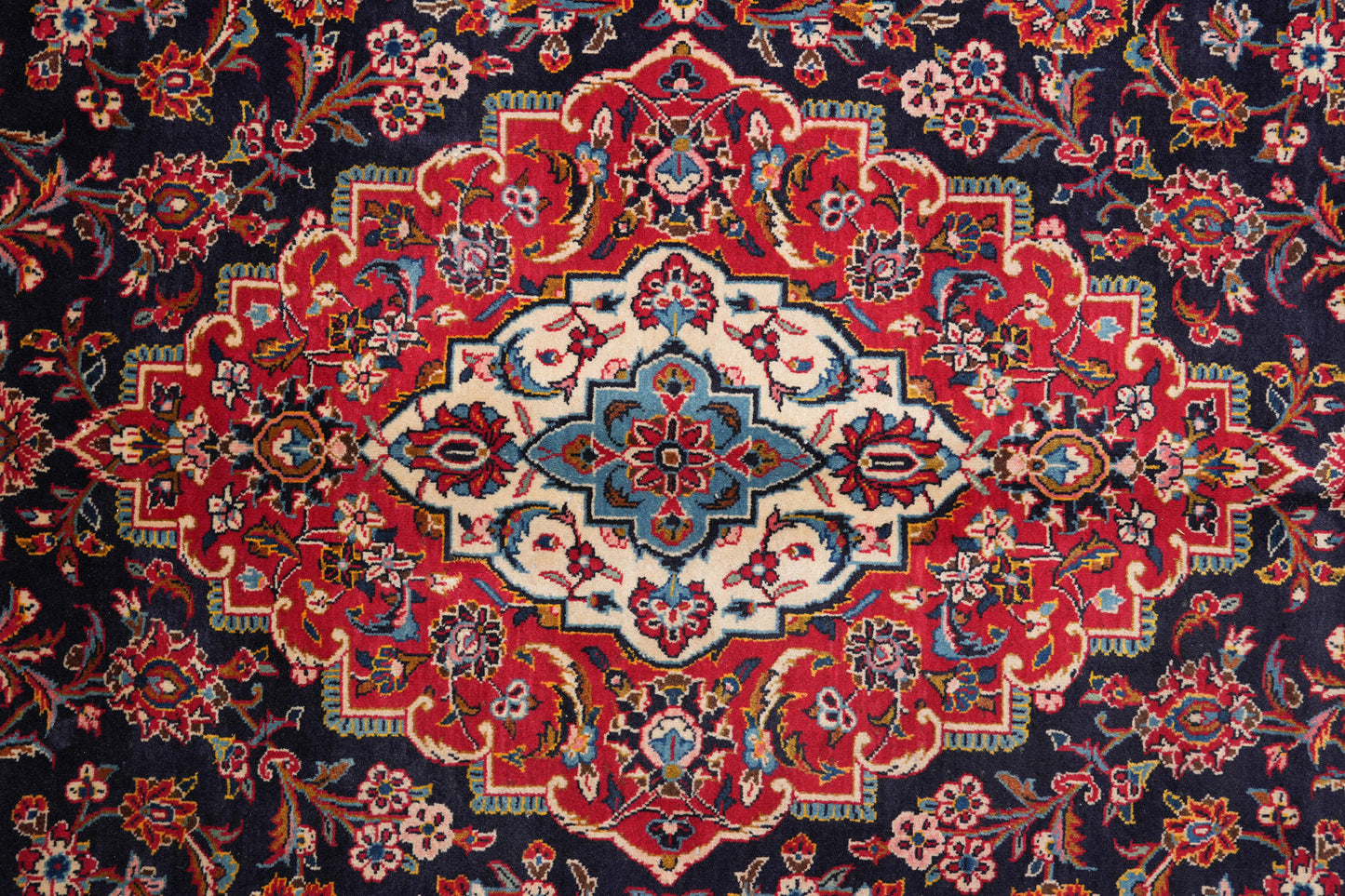 Signed Kashan-style navy rug, border pattern detail