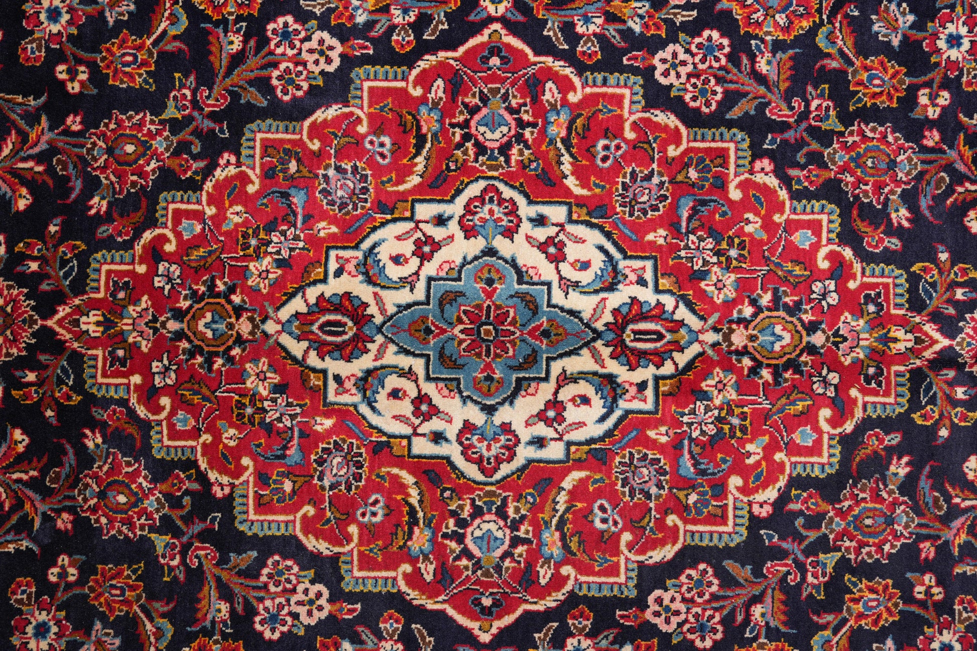 Signed Kashan-style navy rug, border pattern detail