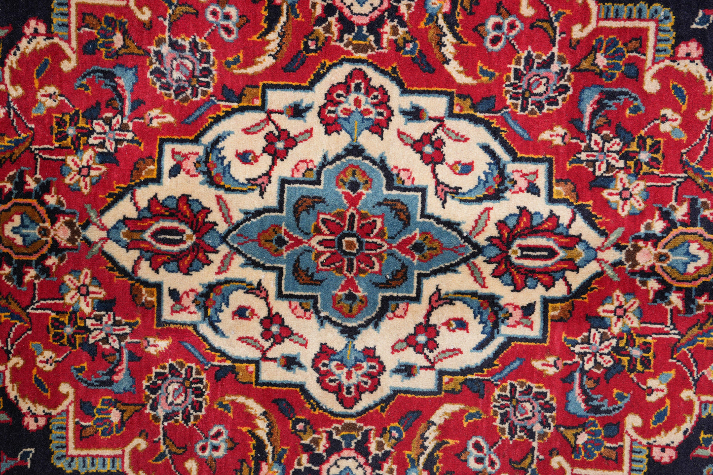 Signed Kashan-style navy rug, corner motif with floral arabesques